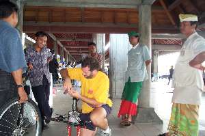 Joe unpacks at the Denpasar Airport in Bali, surrounded by a crowd.